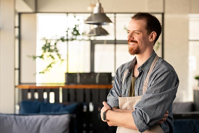 Replay Products | A man in an apron standing in a restaurant with disposable packaging.