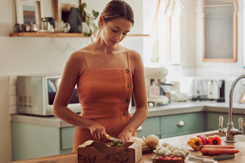 Cooking, healthy and cutting vegetables while a woman prepares an organic, nutritional and vegetari